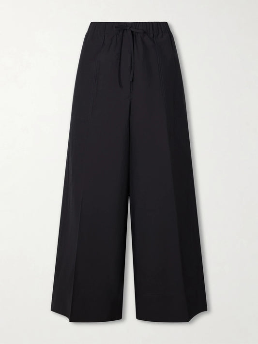 Image of a model wearing Pants. Product name - Wide Summer Cotton-blend Wide-leg Pants in Black colour by brand - TOTEME