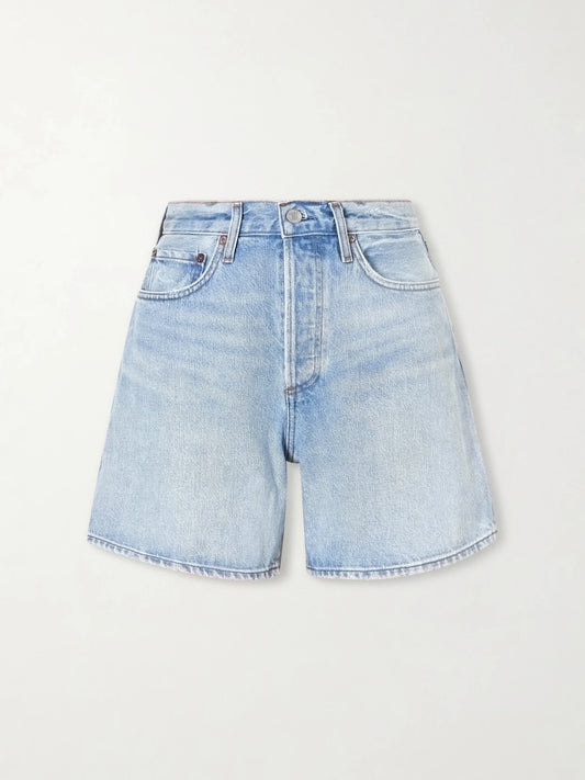 Image of a model wearing Shorts. Product name - Dame Denim Shorts in Mid denim colour by brand - AGOLDE