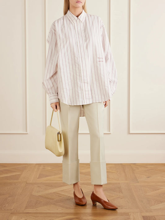 Image of a model wearing Tops. Product name - Amari Pinstriped Cotton And Silk-blend Shirt in Cream colour by brand - Calvin Klein Collection