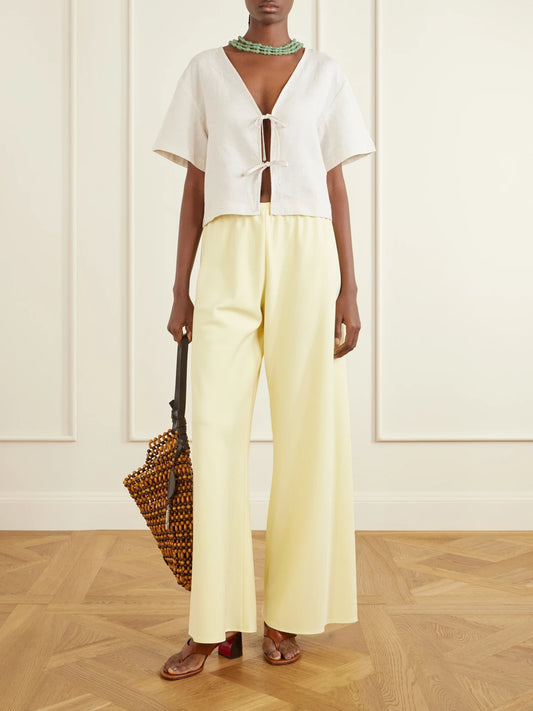 Image of a model wearing Tops. Product name - Ava Linen Blouse in Off-white colour by brand - STAUD