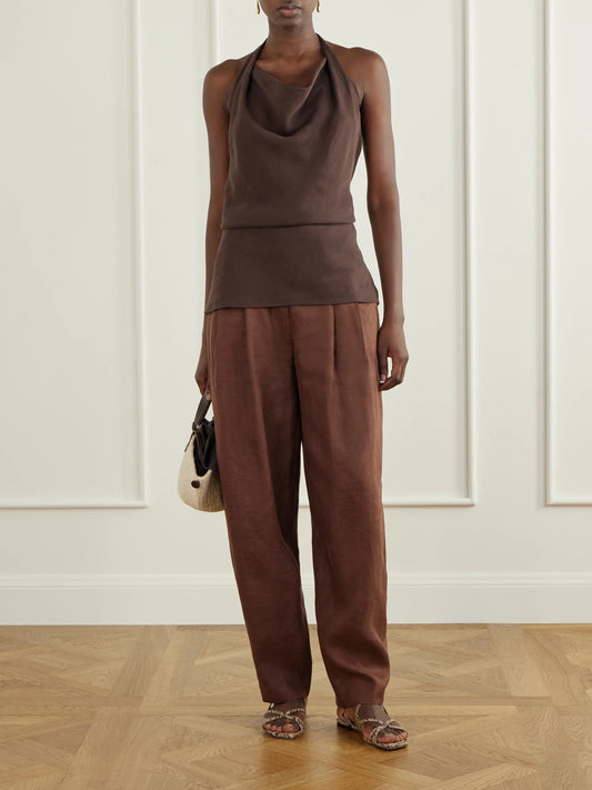 Image of a model wearing Pants. Product name - Seguirte Pleated Linen Tapered Pants in Brown colour by brand - Andres Otalora