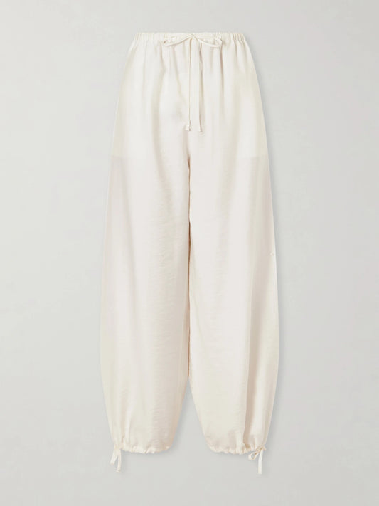 Image of a model wearing Pants. Product name - Parachute Lyocell-blend Balloon Pants in Ecru colour by brand - TOTEME