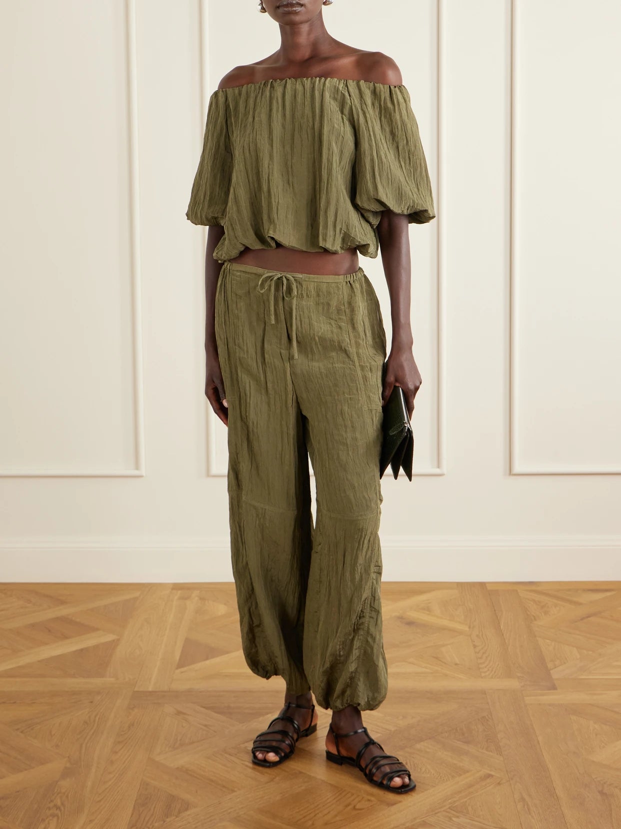 Image of a model wearing Pants. Product name - Freya Tapered Crepon Parachute Pants in Army green colour by brand - SIMKHAI