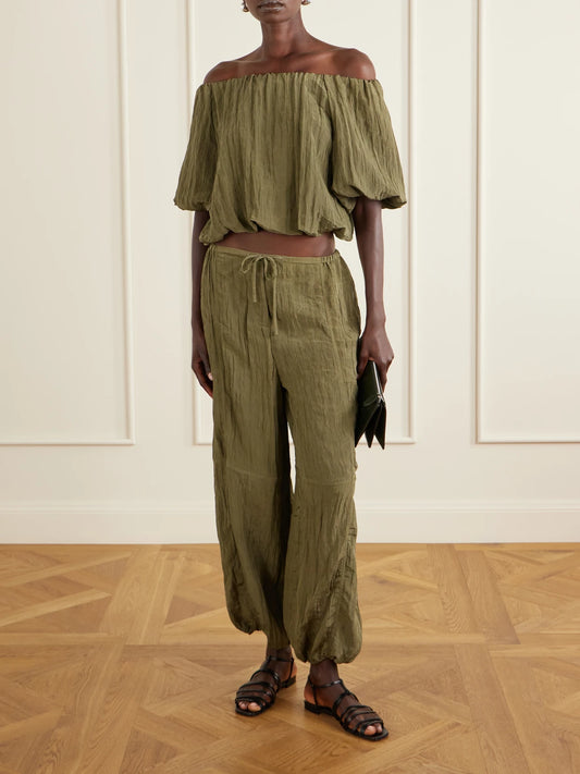 Image of a model wearing Pants. Product name - Freya Tapered Crepon Parachute Pants in Army green colour by brand - SIMKHAI