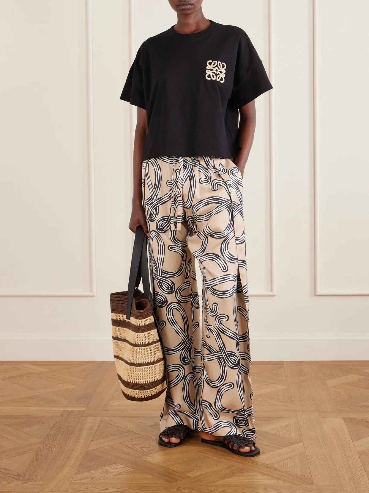 Image of a model wearing Tops. Product name - + Paula's Ibiza Anagram Embroidered Cotton-jersey T-shirt in Black colour by brand - LOEWE