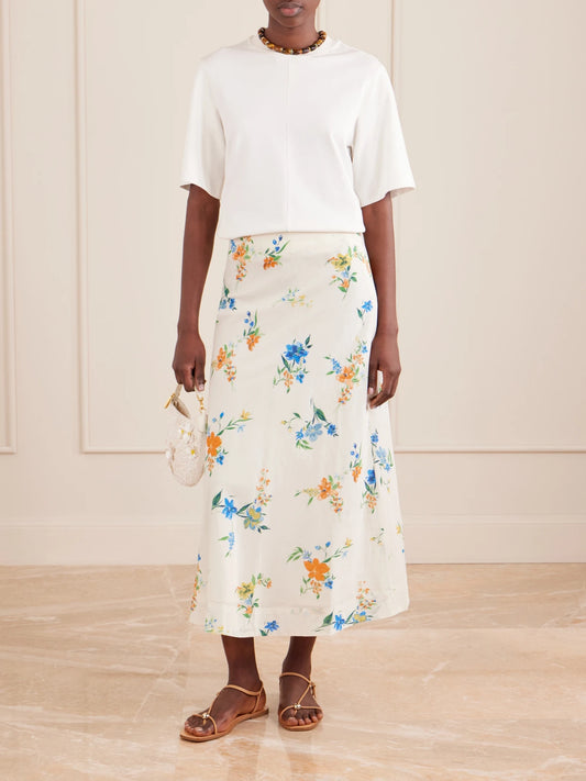 Image of a model wearing Skirts. Product name - Mila Floral-print Organic Cotton Midi Skirt in Cream colour by brand - SKALL