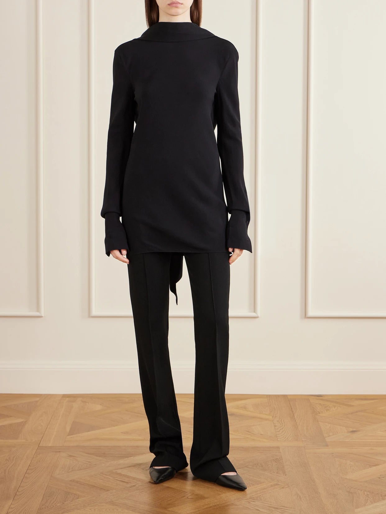 Image of a model wearing Tops. Product name - Evo Crepe Blouse in Black colour by brand - The Row