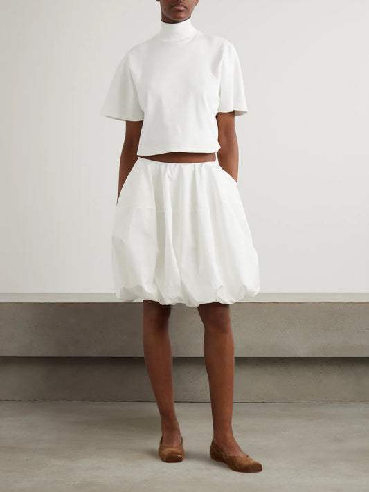Image of a model wearing Skirts. Product name - Gathered Cotton-poplin Mini Skirt in White colour by brand - Alaïa