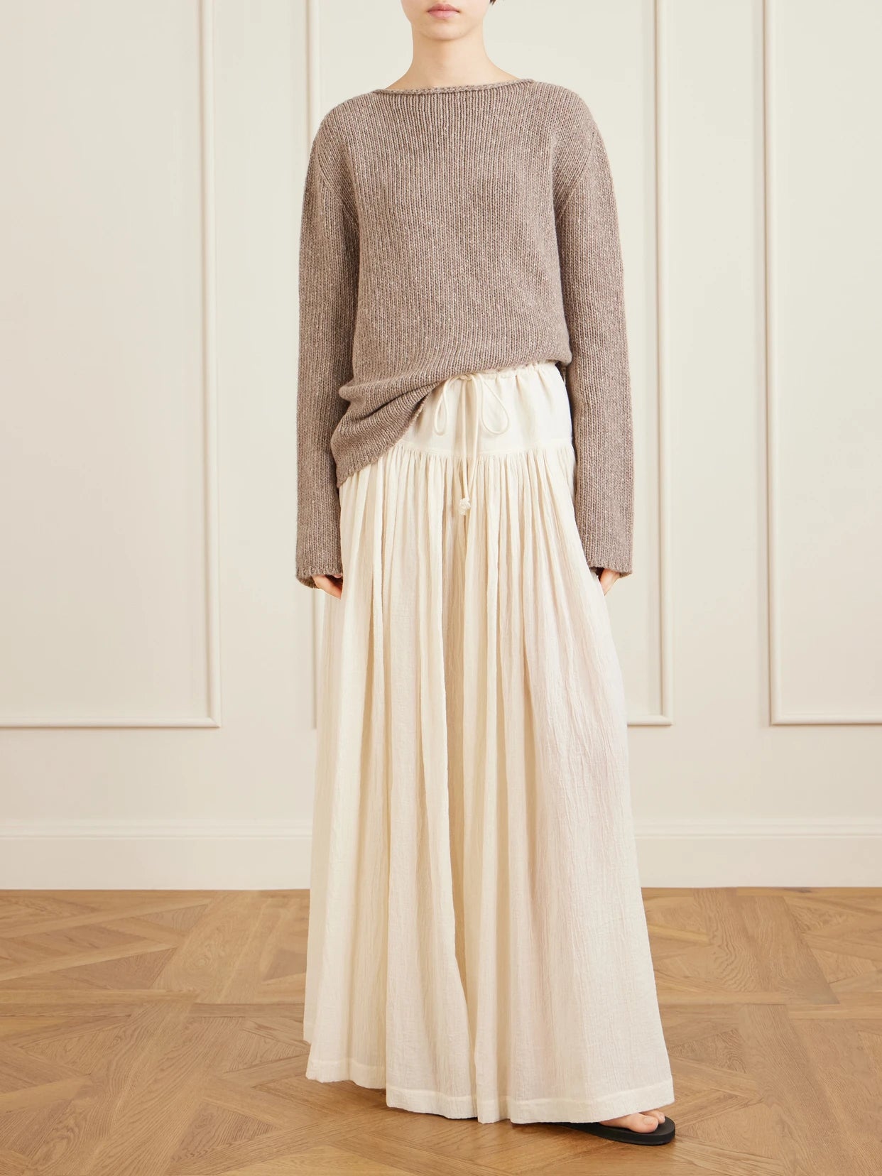 Image of a model wearing Outerwear. Product name - Nitha Cashmere Sweater in Cream colour by brand - The Row