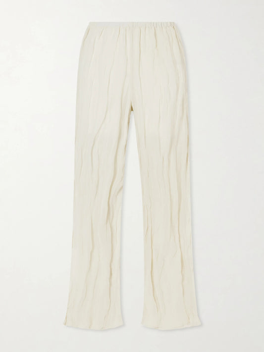 Image of a model wearing Pants. Product name - Crinkled Cotton-blend Wide-leg Pants in Cream colour by brand - RÓHE