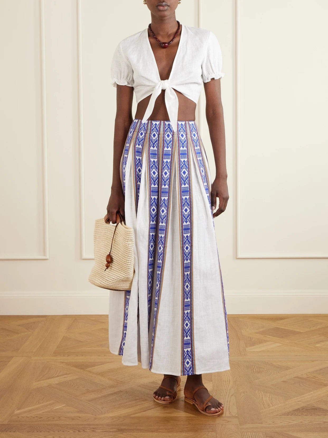 Image of a model wearing Tops. Product name - Poppy Knotted Linen Cropped Top in White colour by brand - Emporio Sirenuse