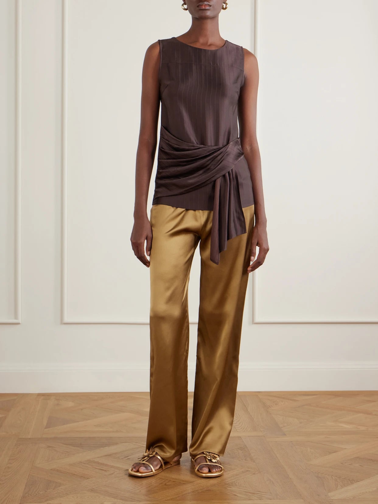 Image of a model wearing Pants. Product name - Playa Silk-satin Straight-leg Pants in Gold colour by brand - Sara Cristina