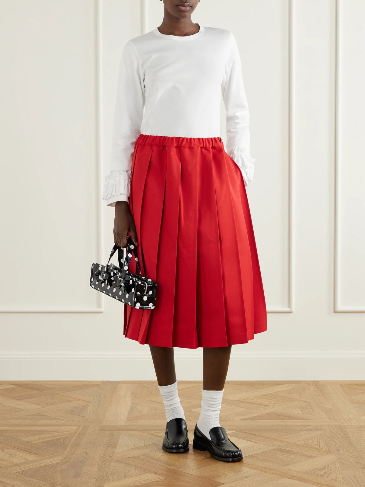 Image of a model wearing Skirts. Product name - Pleated Gabardine Midi Skirt in Red colour by brand - Comme des Garçons GIRL