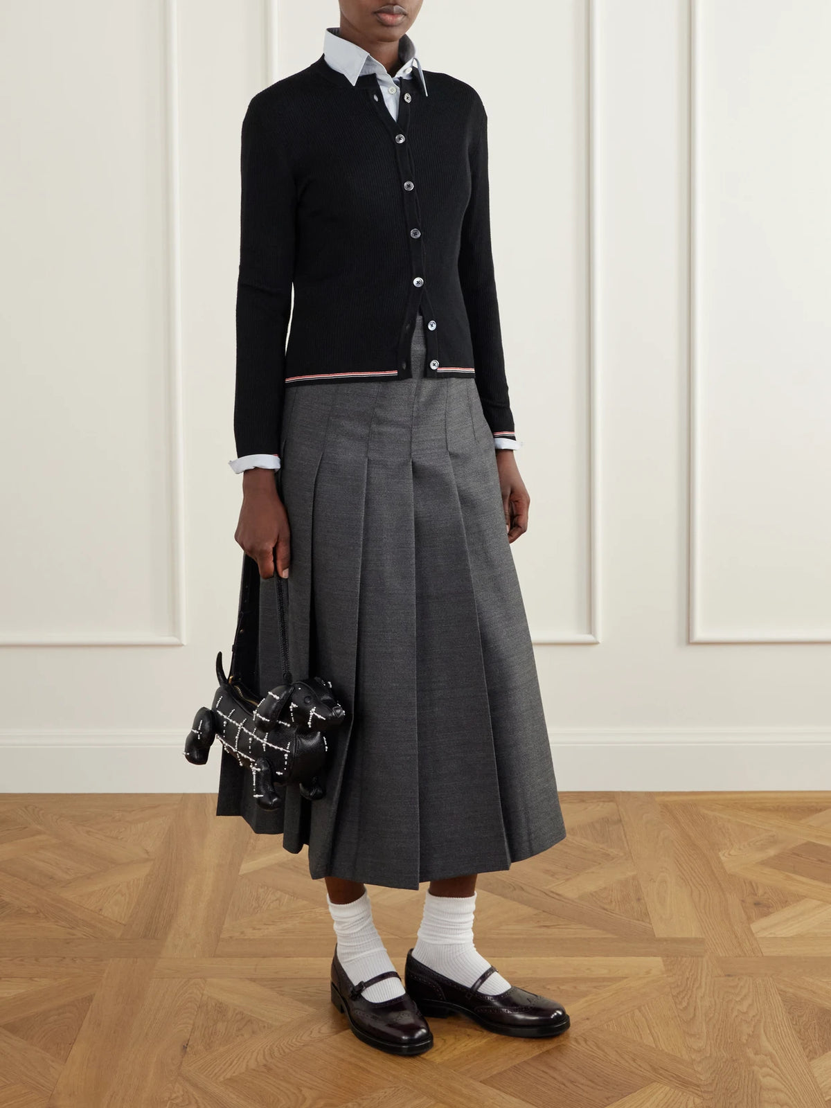 Image of a model wearing Outerwear. Product name - Ribbed Merino Wool Cardigan in Black colour by brand - Thom Browne