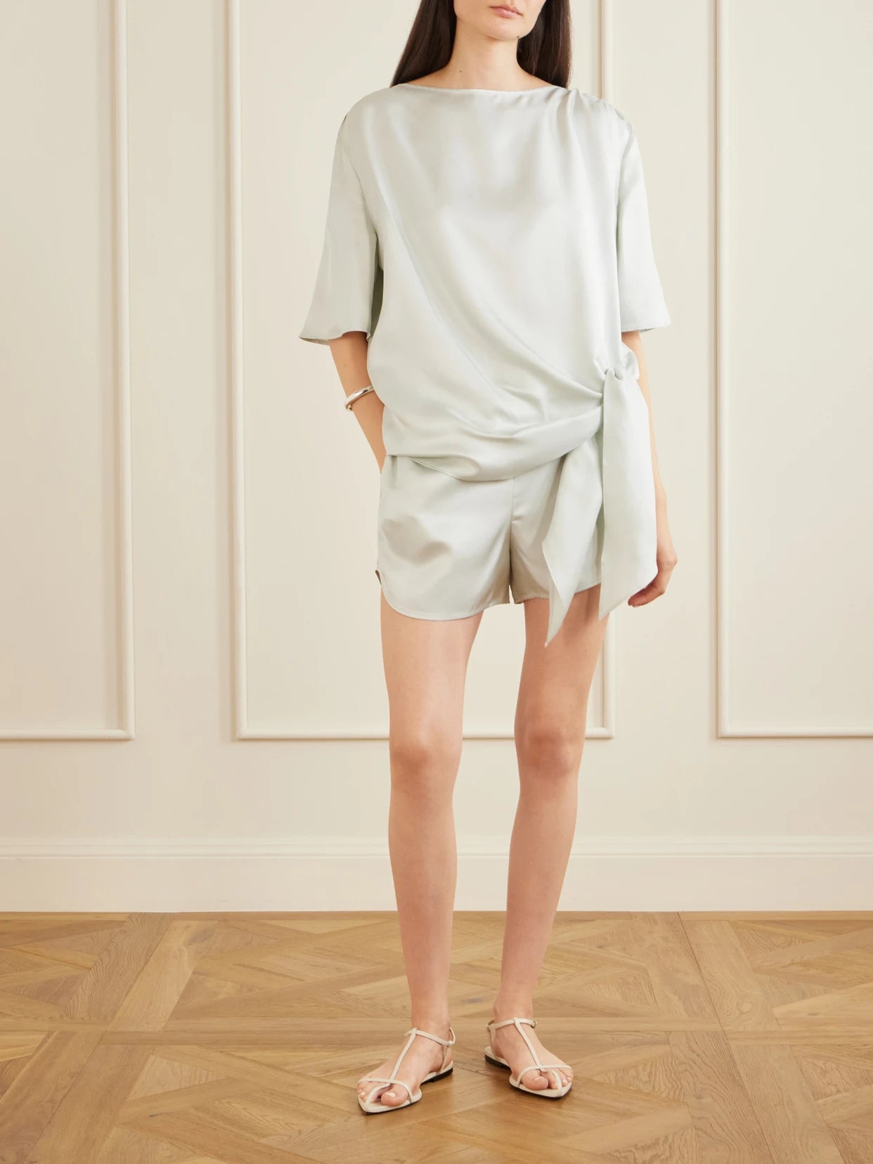 Image of a model wearing Tops. Product name - Mano Knotted Silk-twill Blouse in Light green colour by brand - Loulou de Saison