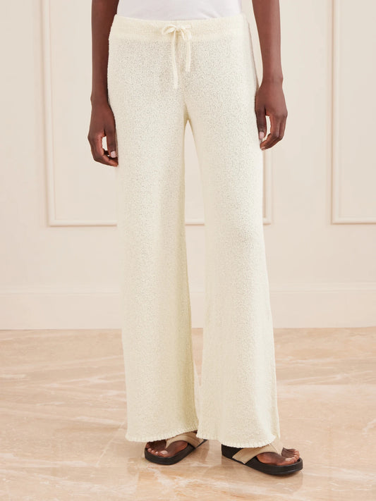 Image of a model wearing Pants. Product name - Calla Cotton-bouclé Flared Pants in Ecru colour by brand - Suzie Kondi