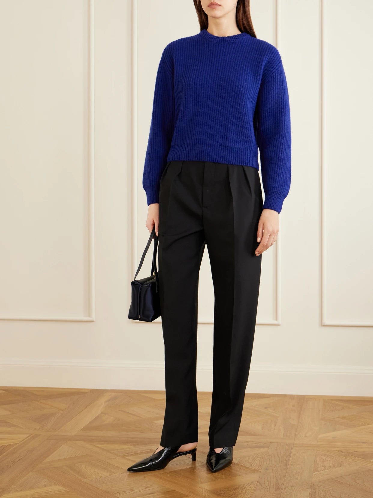 Image of a model wearing Pants. Product name - Pleated Wool Straight-leg Pants in Black colour by brand - Jil Sander
