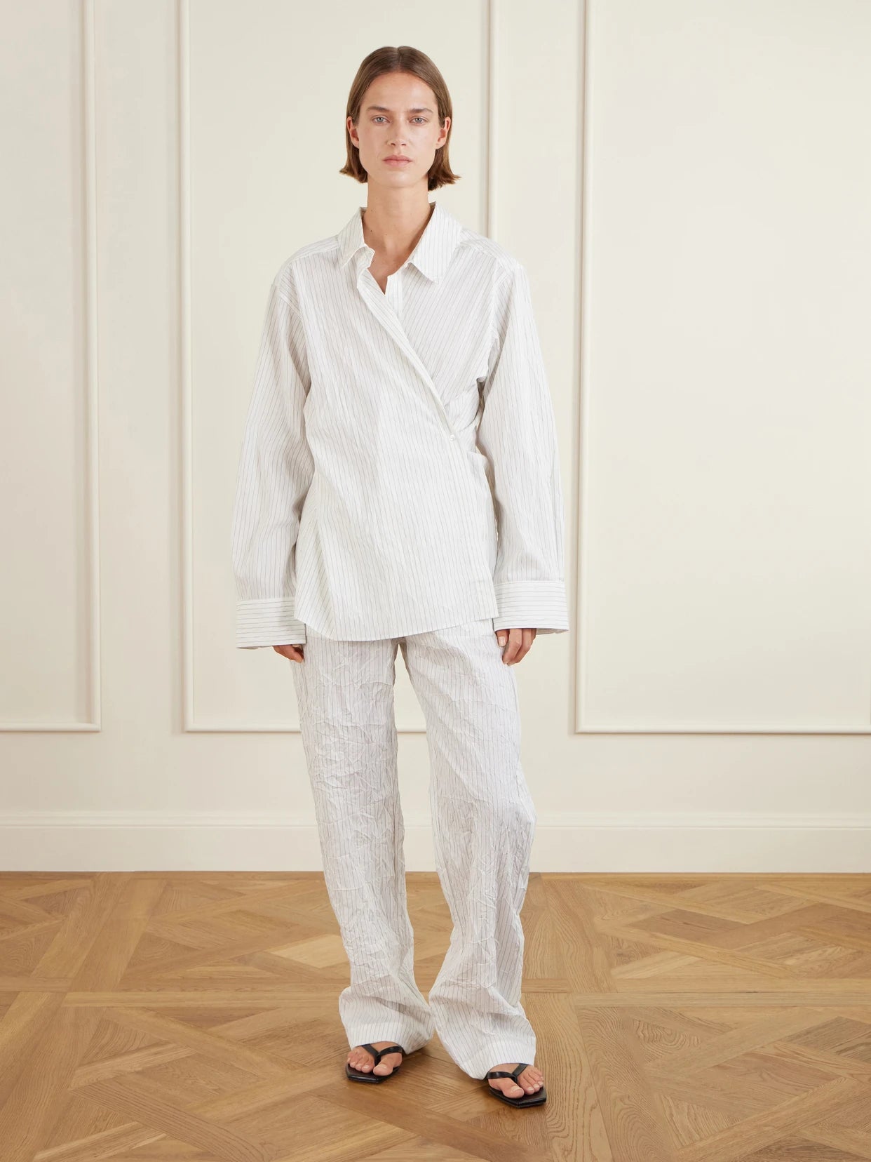 Image of a model wearing Pants. Product name - Striped Crepon Wide-leg Pants in White colour by brand - RÓHE