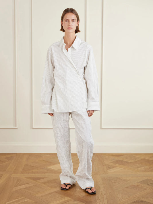 Image of a model wearing Pants. Product name - Striped Crepon Wide-leg Pants in White colour by brand - RÓHE