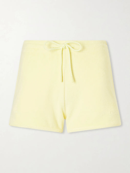 Image of a model wearing Shorts. Product name - Embroidered Cotton-terry Shorts in Yellow colour by brand - Hunza G