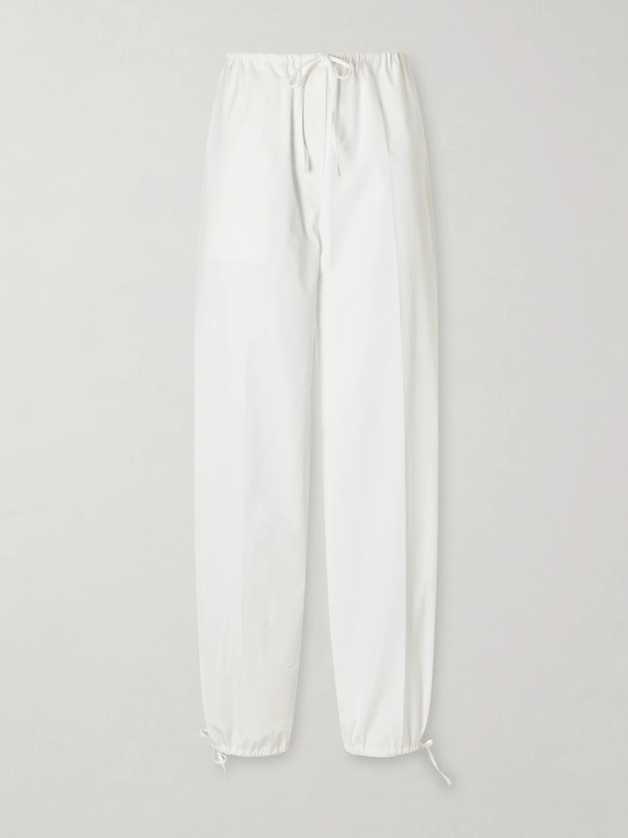 Image of a model wearing Pants. Product name - Cotton Wide-leg Drawstring Balloon Pants in White colour by brand - TOTEME