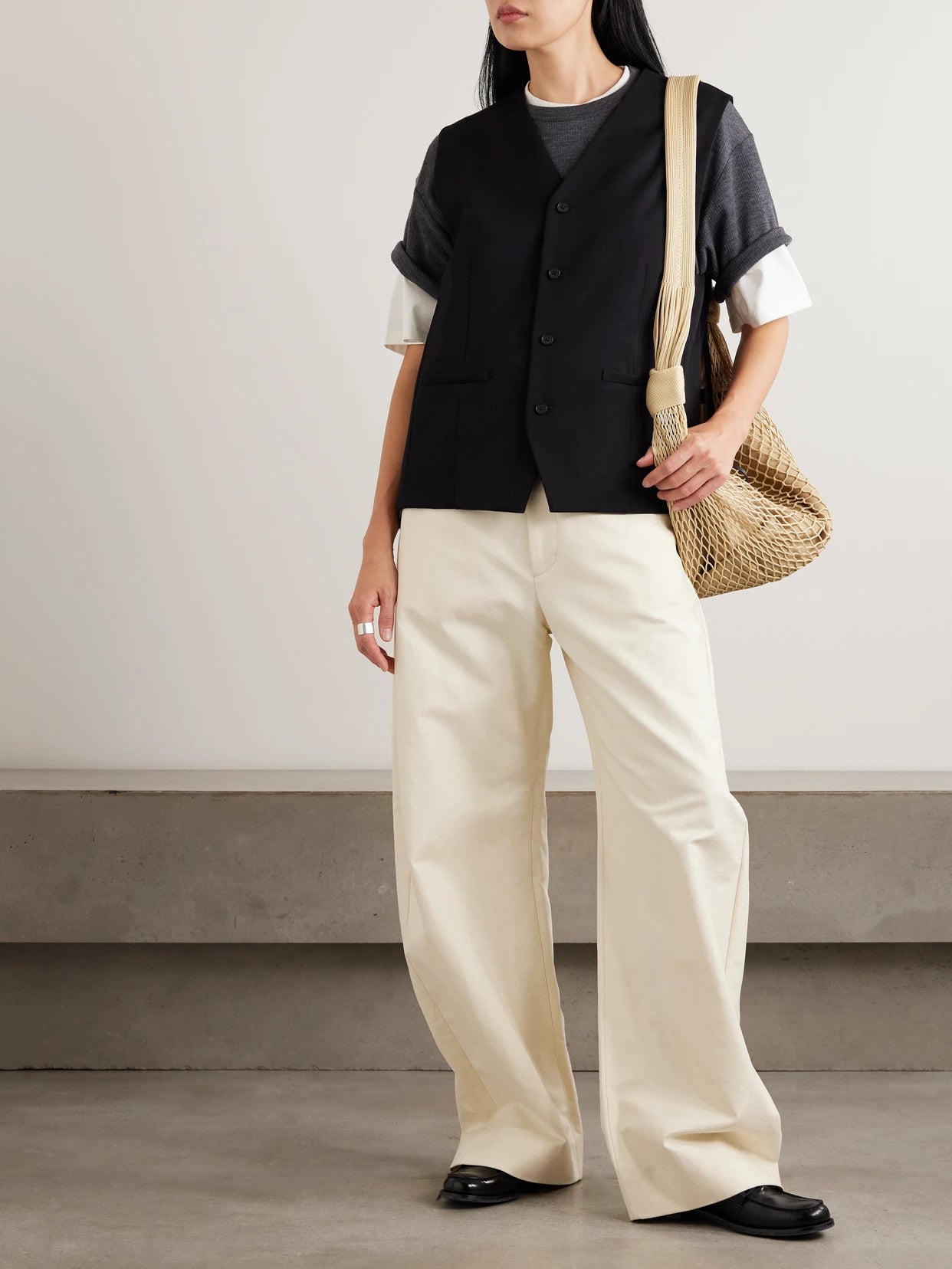 Image of a model wearing Tops. Product name - Belted Wool-gabardine Vest in Black colour by brand - ssstein