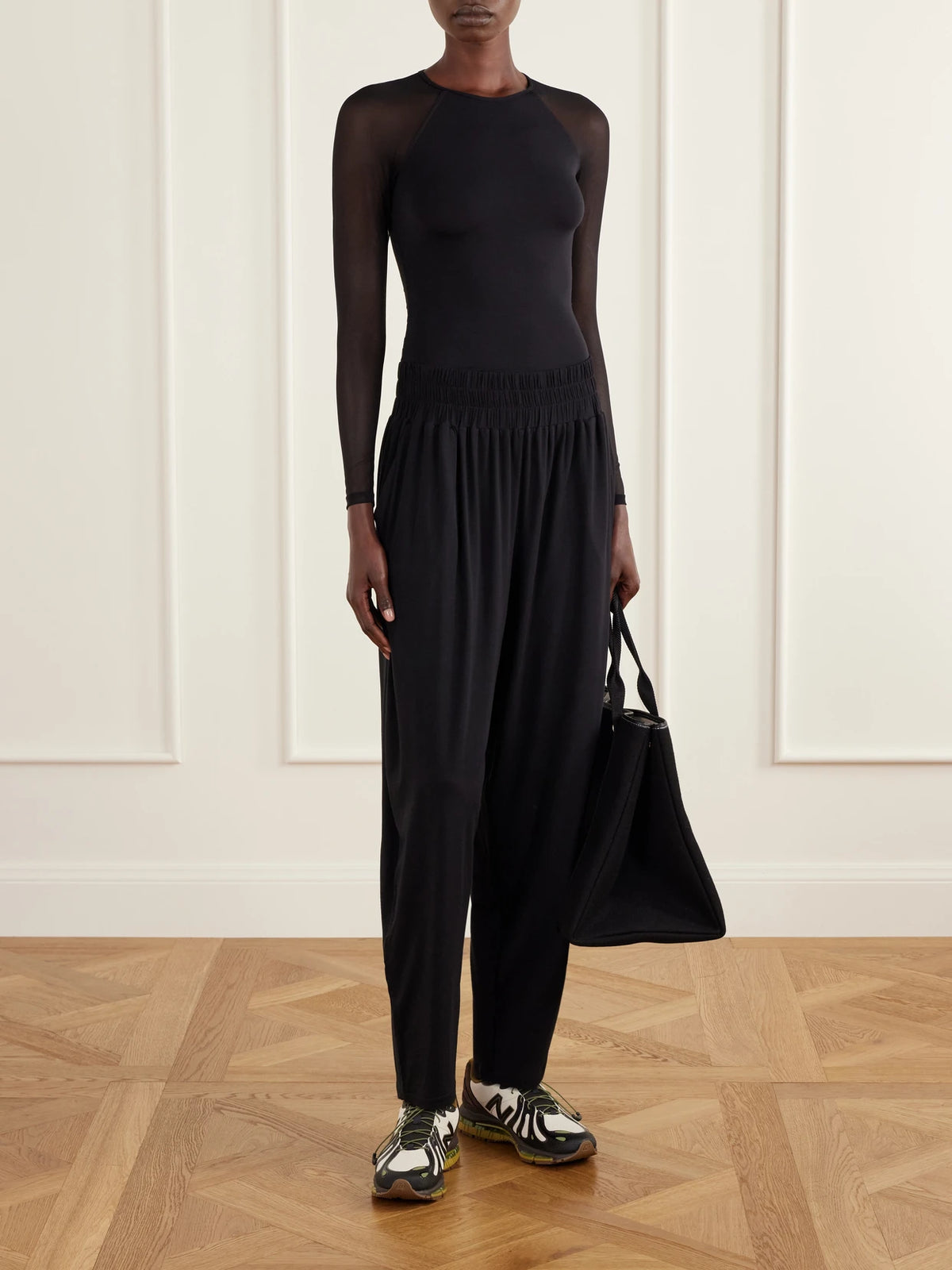 Image of a model wearing Pants. Product name - Koch Pleated Stretch-jersey Tapered Sweatpants in Black colour by brand - Eres