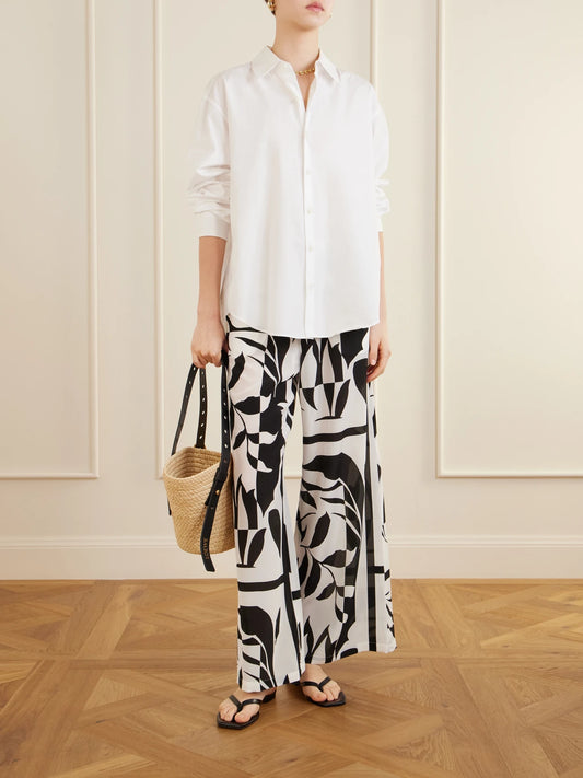 Image of a model wearing Pants. Product name - Beachwear Printed Silk Crepe De Chine Wide-leg Pants in Black colour by brand - Max Mara
