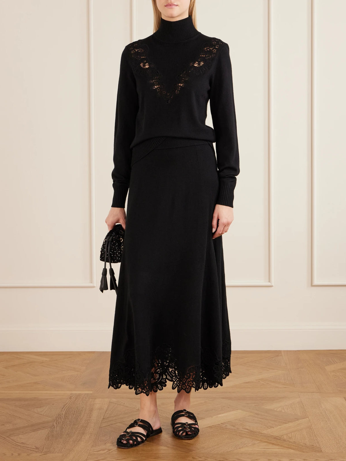 Image of a model wearing Skirts. Product name - Valiant Lace-trimmed Wool Midi Skirt in Black colour by brand - Zimmermann