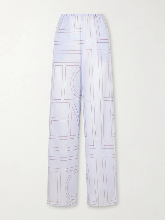 Image of a model wearing Pants. Product name - Embroidered Lyocell And Cotton-blend Wide-leg Pajama Pants in Light blue colour by brand - TOTEME