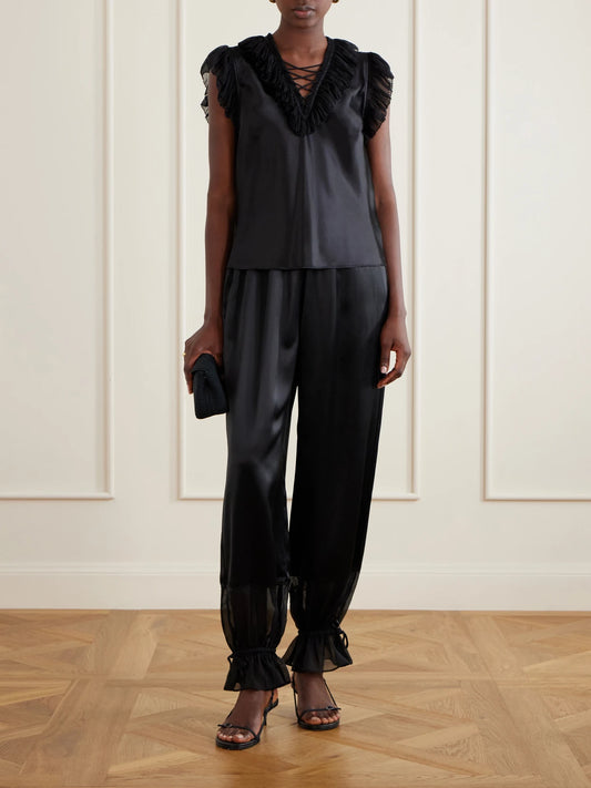 Image of a model wearing Tops. Product name - Ilyana Ruffled Silk Blouse in Black colour by brand - Ulla Johnson
