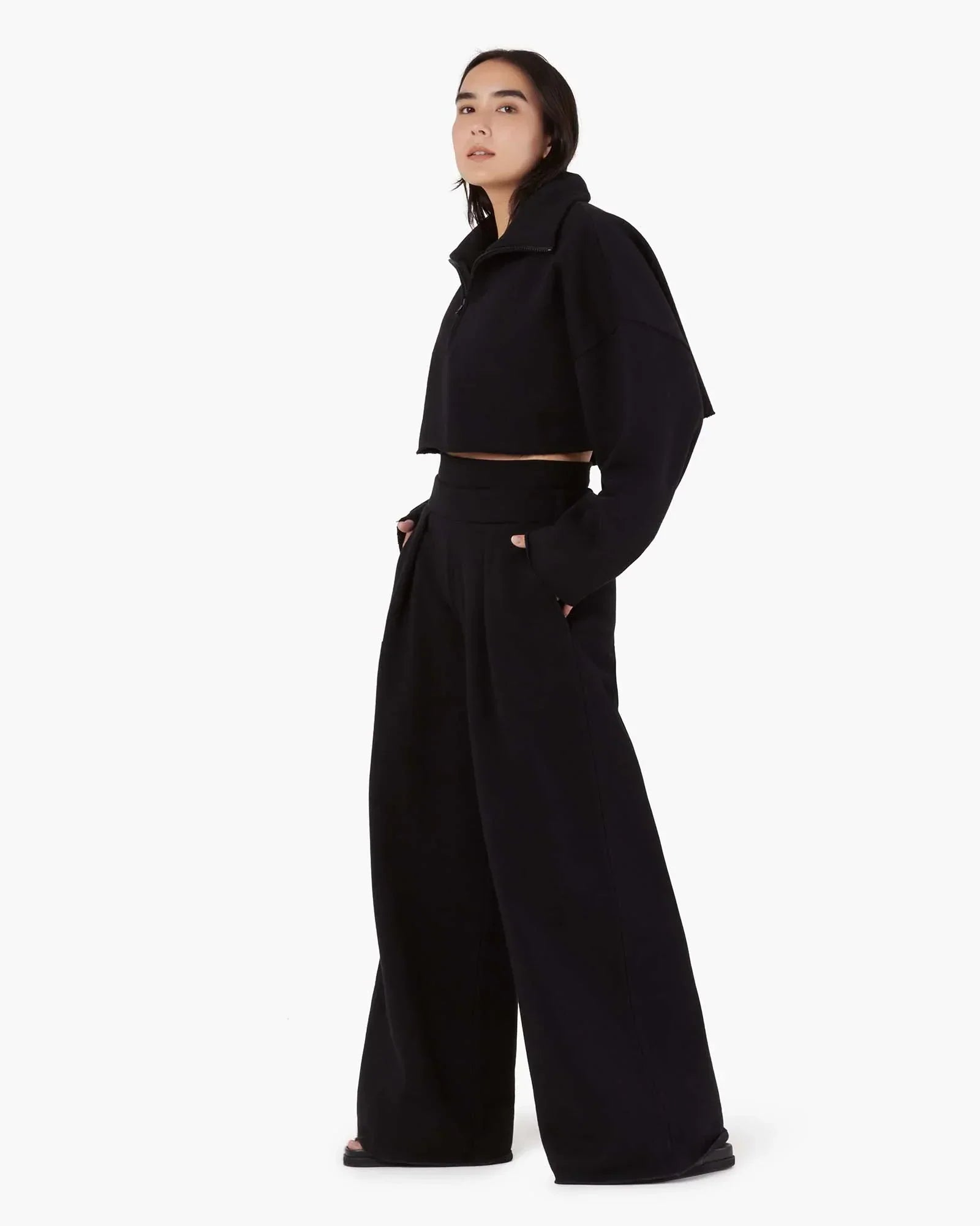 Image of a model wearing Outerwear. Productname: Core Fleece Cropped Half Zip Black in Black colour by brand - TKEES