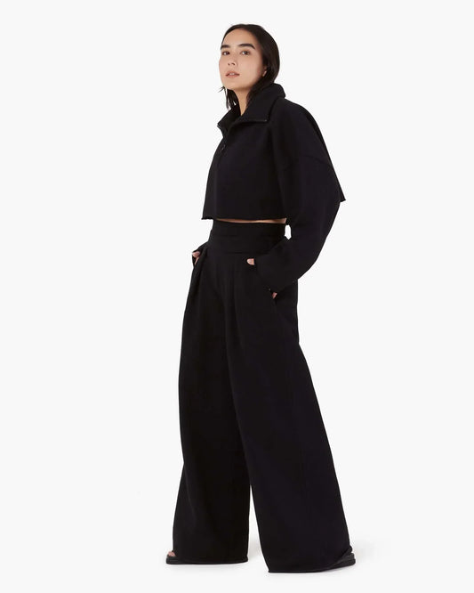 Image of a model wearing Outerwear. Productname: Core Fleece Cropped Half Zip Black in Black colour by brand - TKEES