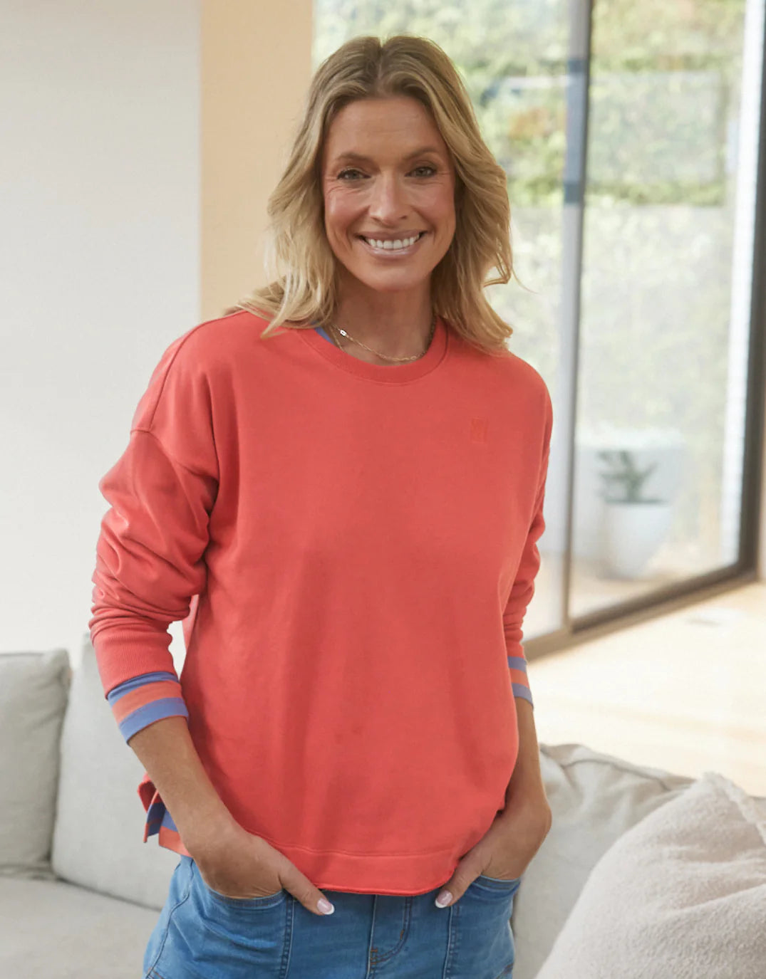 Image of a model wearing Outerwear. Product name - Staple Scoop Hem Sweat Washed Red in Washed Red colour by brand - White & Co.