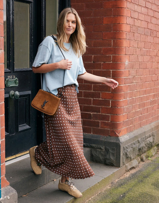 Image of a model wearing Skirts. Product name - Ascot Slip Skirt Choc/Blue Polka Dot in Choc/Blue Polka Dot colour by brand - White & Co.