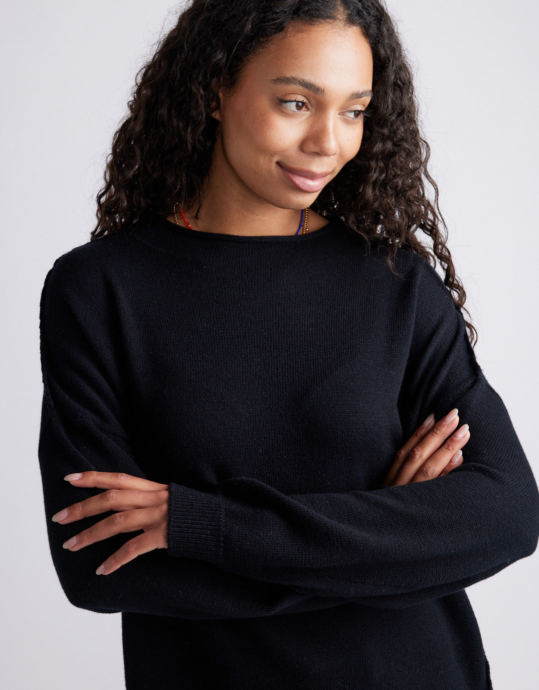 Image of a model wearing Outerwear. Product name - Biarritz Raw Edge Knit Black in Black colour by brand - White & Co.