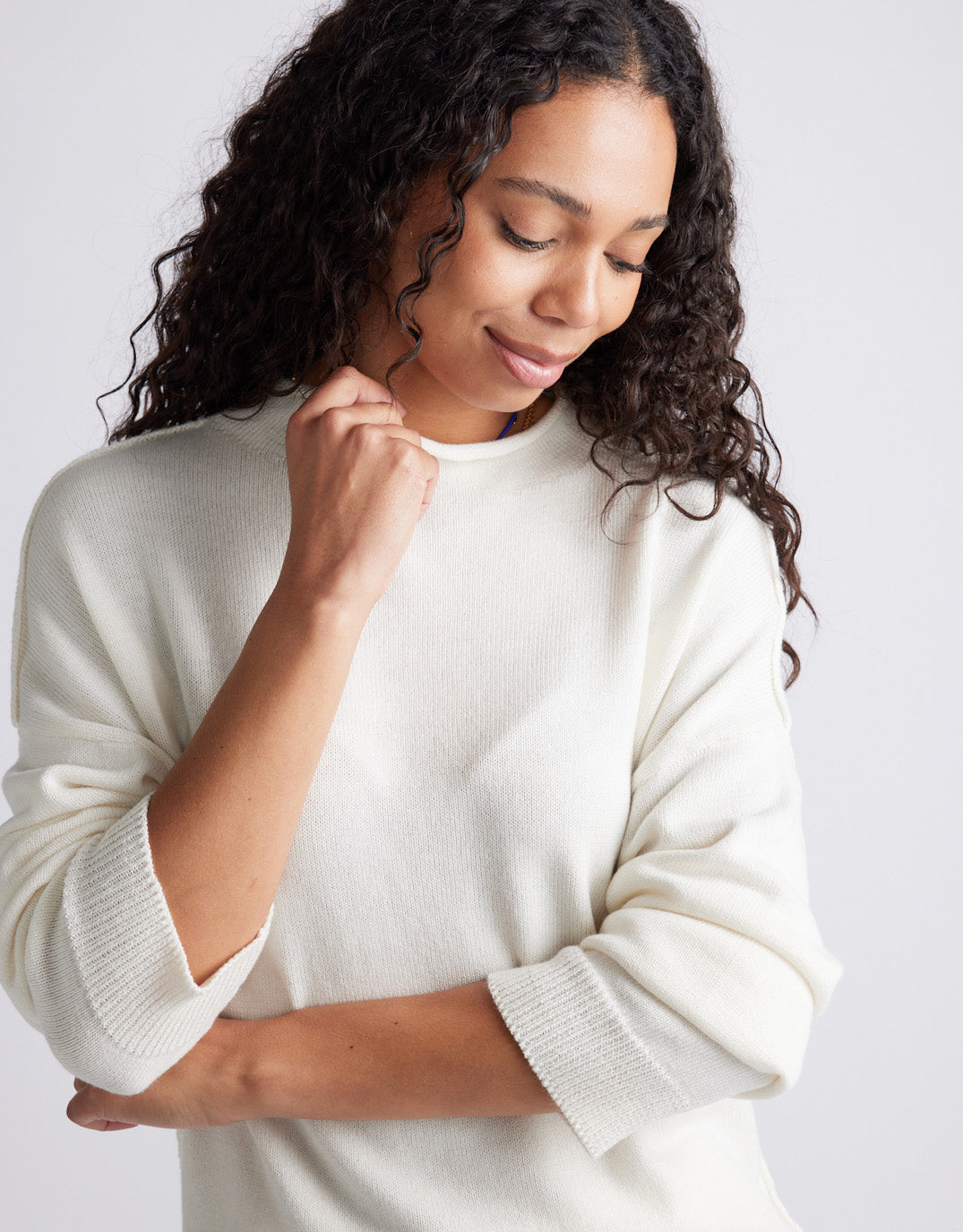 Image of a model wearing Outerwear. Product name - Biarritz Raw Edge Knit White in White colour by brand - White & Co.