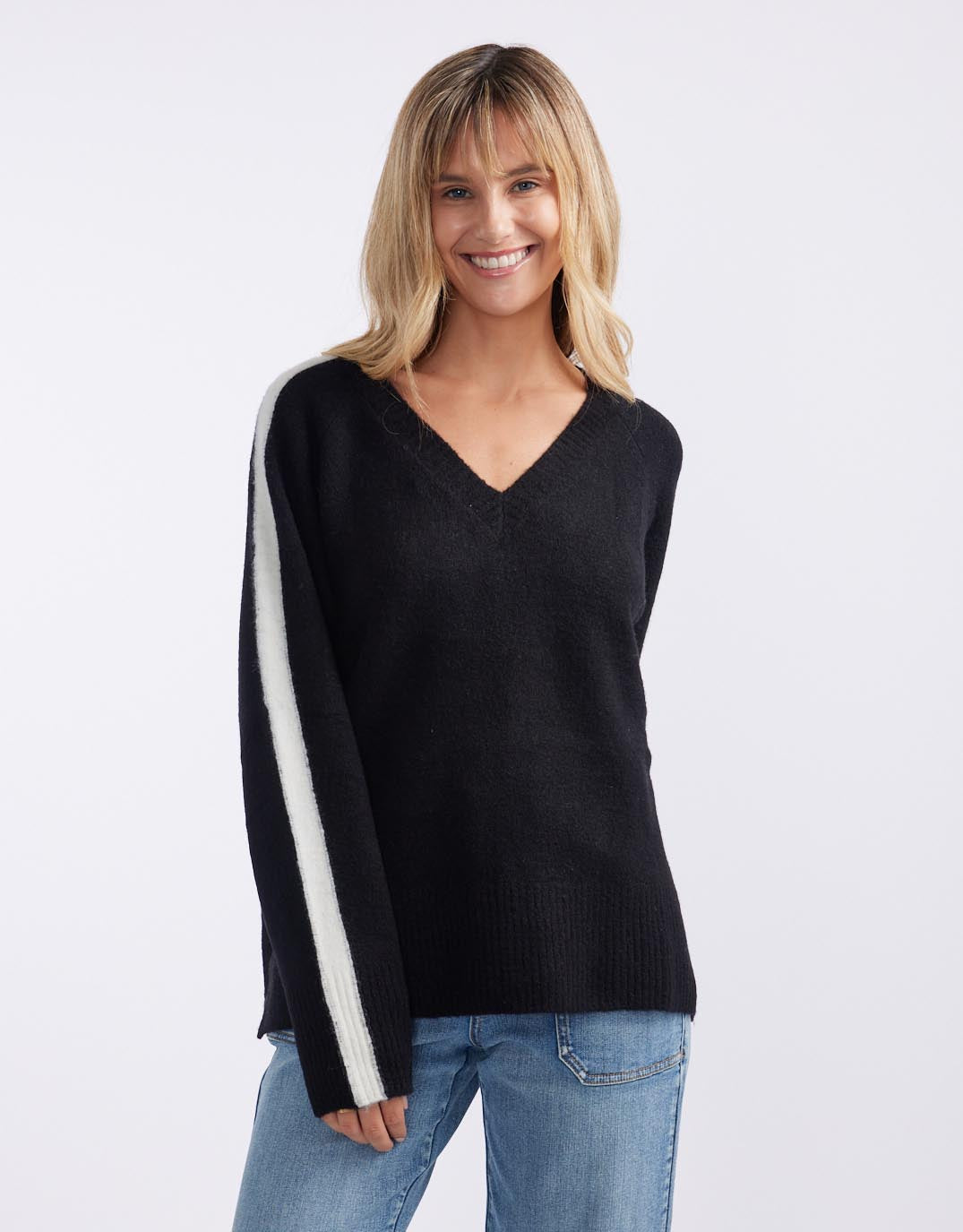 Image of a model wearing Outerwear. Productname: Chalet V Neck Knit Jumper - in Black/White colour by brand - White & Co.