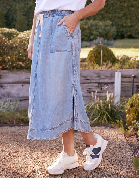 Image of a model wearing Skirts. Productname: Coco Midi Skirt - in Mid Wash colour by brand - White & Co.