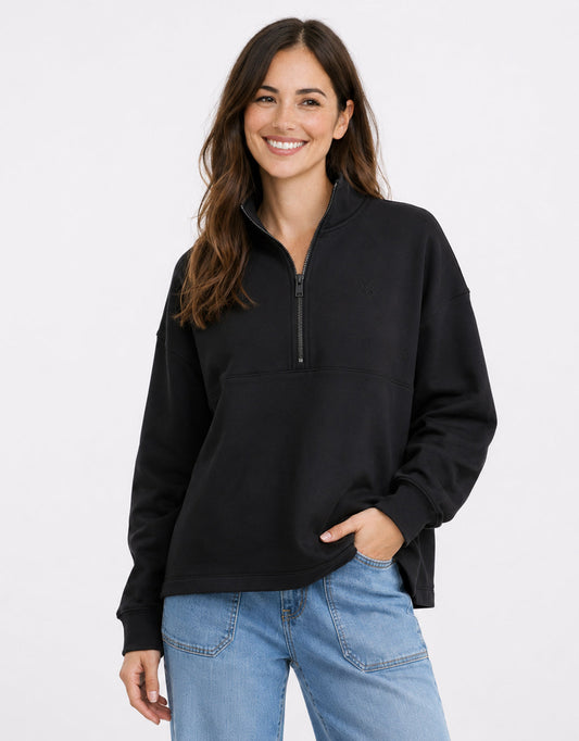 Image of a model wearing Tops. Product name - Escape Super Soft Half Zip Top Black in Black colour by brand - White & Co.