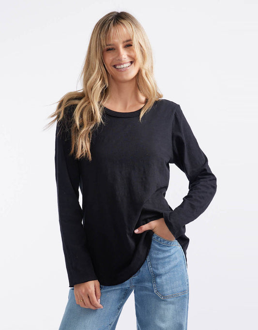Image of a model wearing Tops. Productname: Essential Scoop Hem Long Sleeve T-shirt - in Black colour by brand - White & Co.