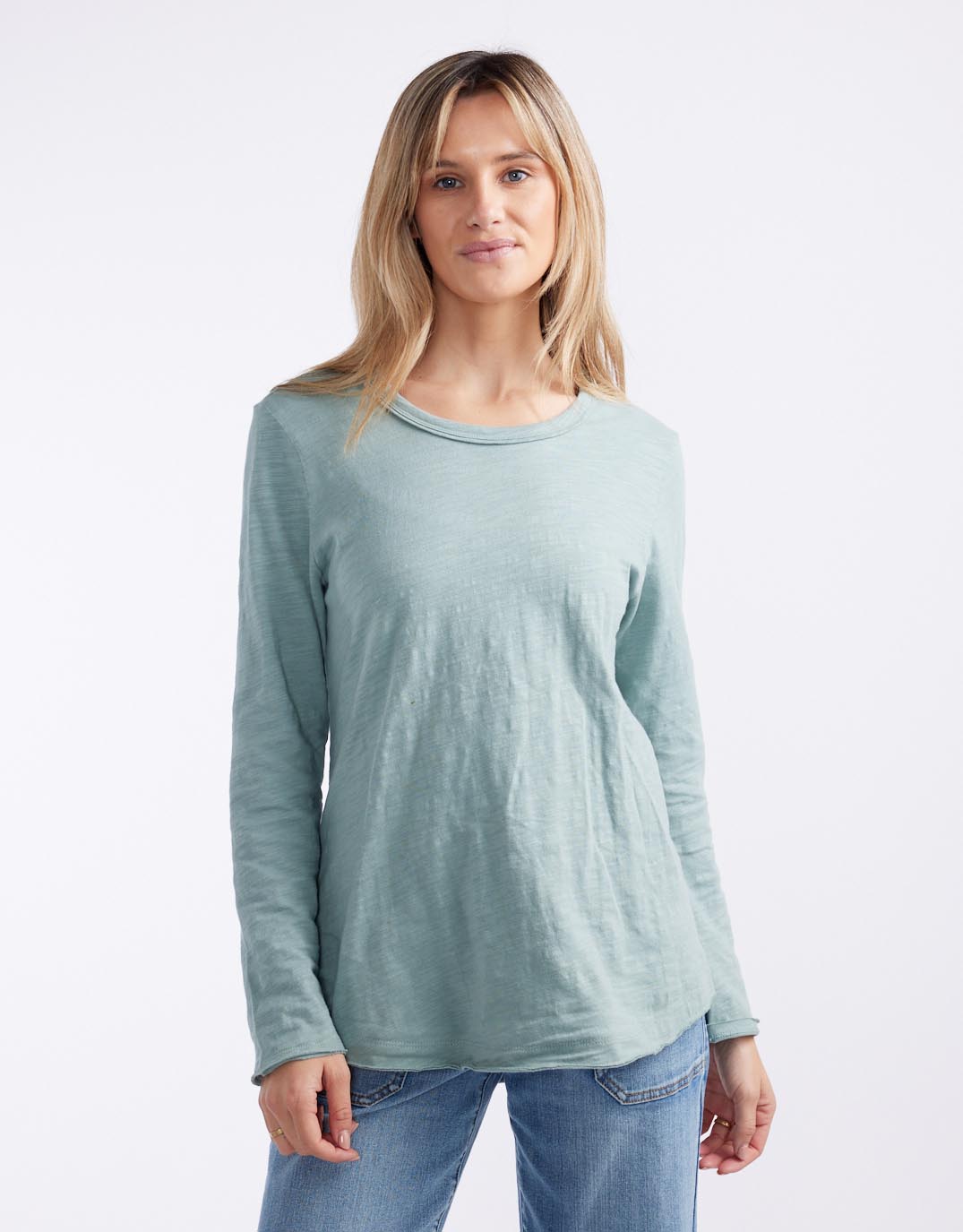 Image of a model wearing Tops. Productname: Essential Scoop Hem Long Sleeve T-shirt - in Sage colour by brand - White & Co.