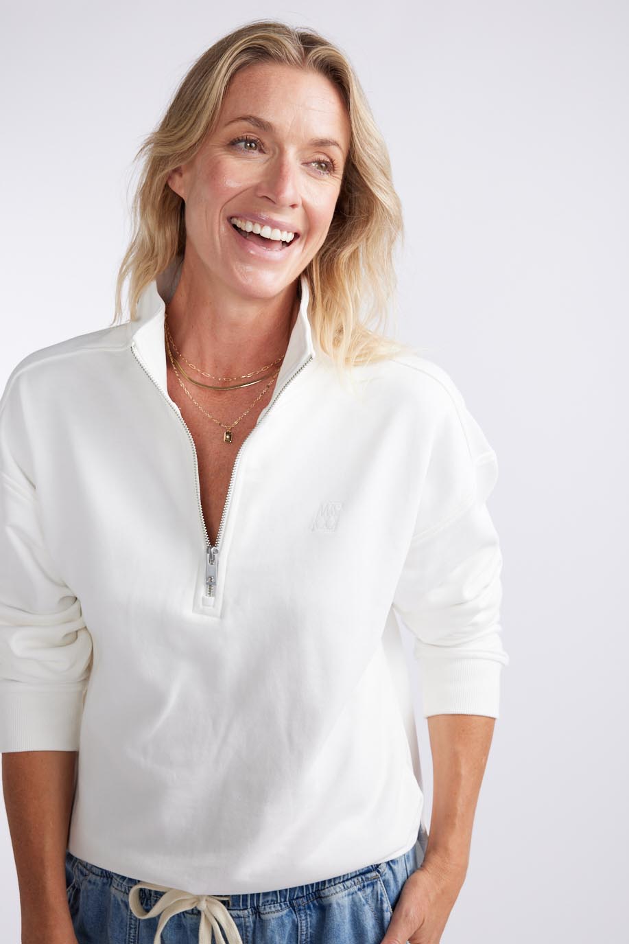 Image of a model wearing Outerwear. Productname: Unwind Half Zip Sweater - in White colour by brand - White & Co.