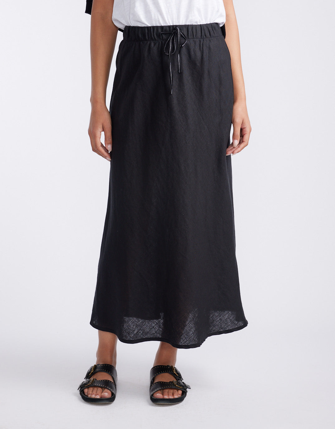 Image of a model wearing Skirts. Product name - Linen Slip Skirt Black in Black colour by brand - White & Co.