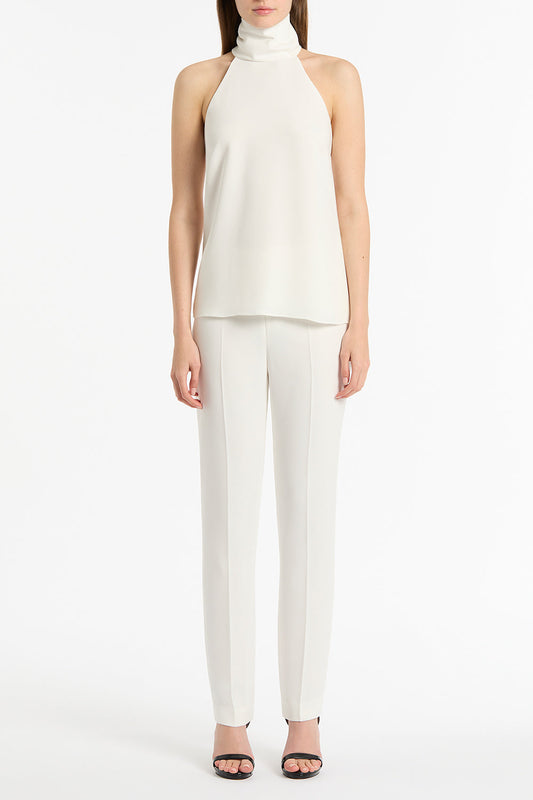 Image of a model wearing Tops. Product name - White Crepe Halter Top in White colour by brand - Carla Zampatti