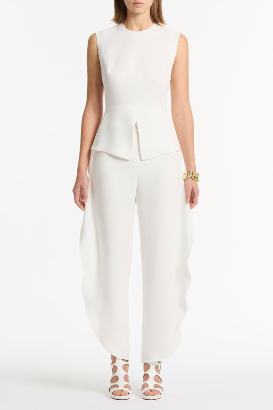 Image of a model wearing Tops. Product name - White Crepe Peplum Top in White colour by brand - Carla Zampatti
