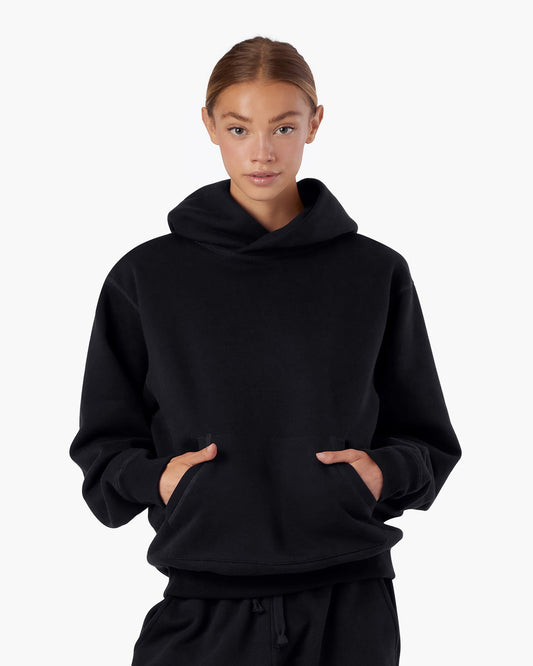Image of a model wearing Outerwear. Productname: Core Fleece Hoodie Black in Black colour by brand - TKEES