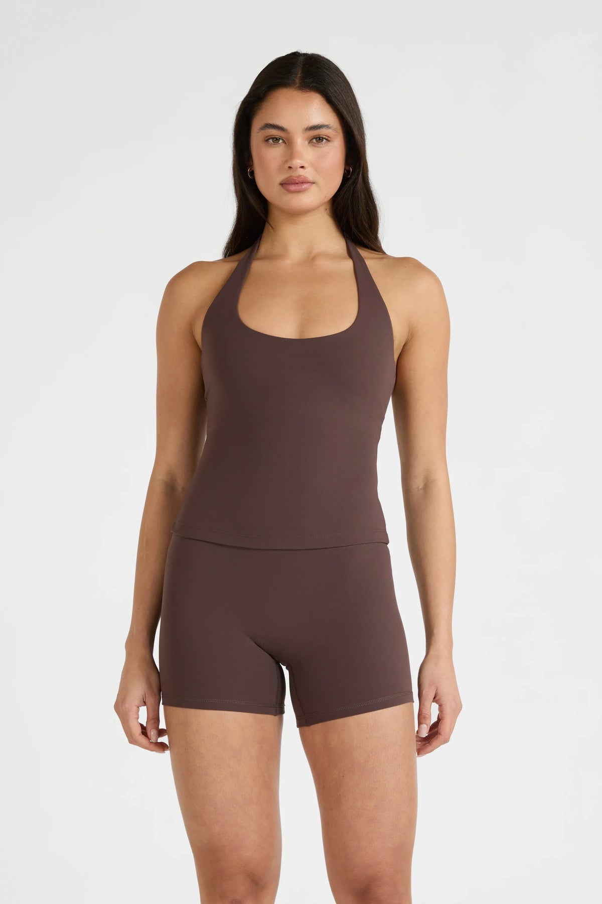 Image of a model wearing Tops. Product name - ALLFENIX CloudCore Halter Tank in Espresso colour by brand - All Fenix